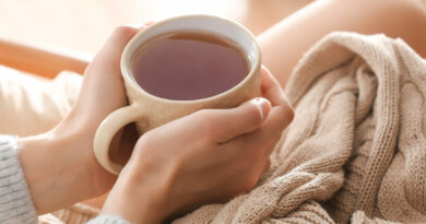 Young woman drinking hot tea at home closeup